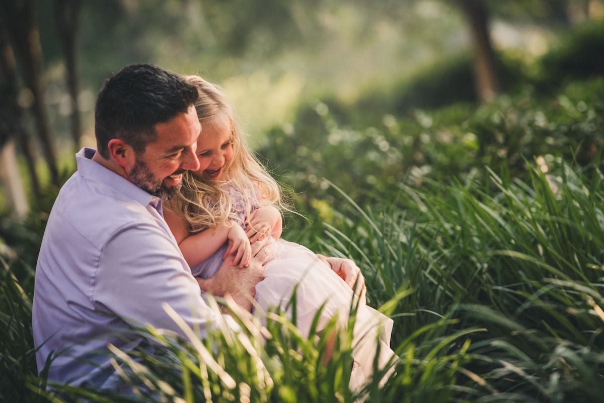 Daddy and daughter laughing in fielnd