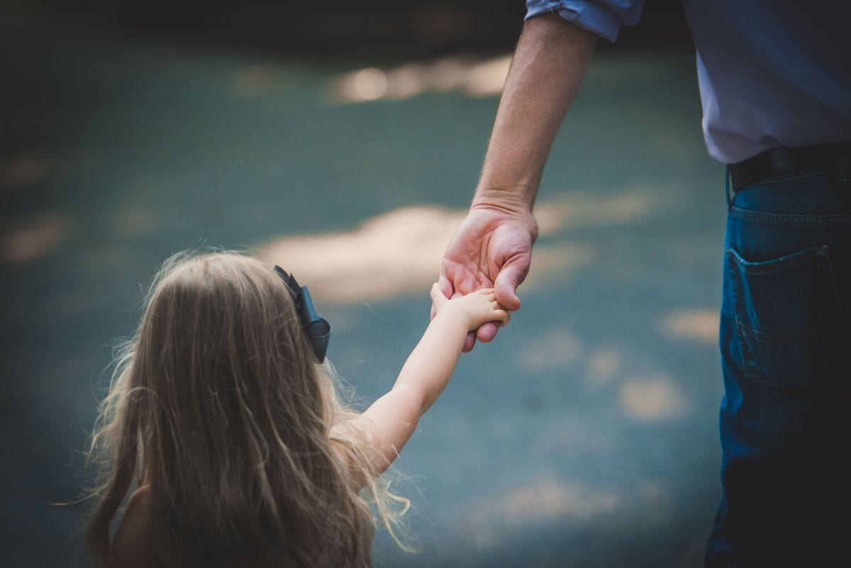 Daughter holding dad's hand